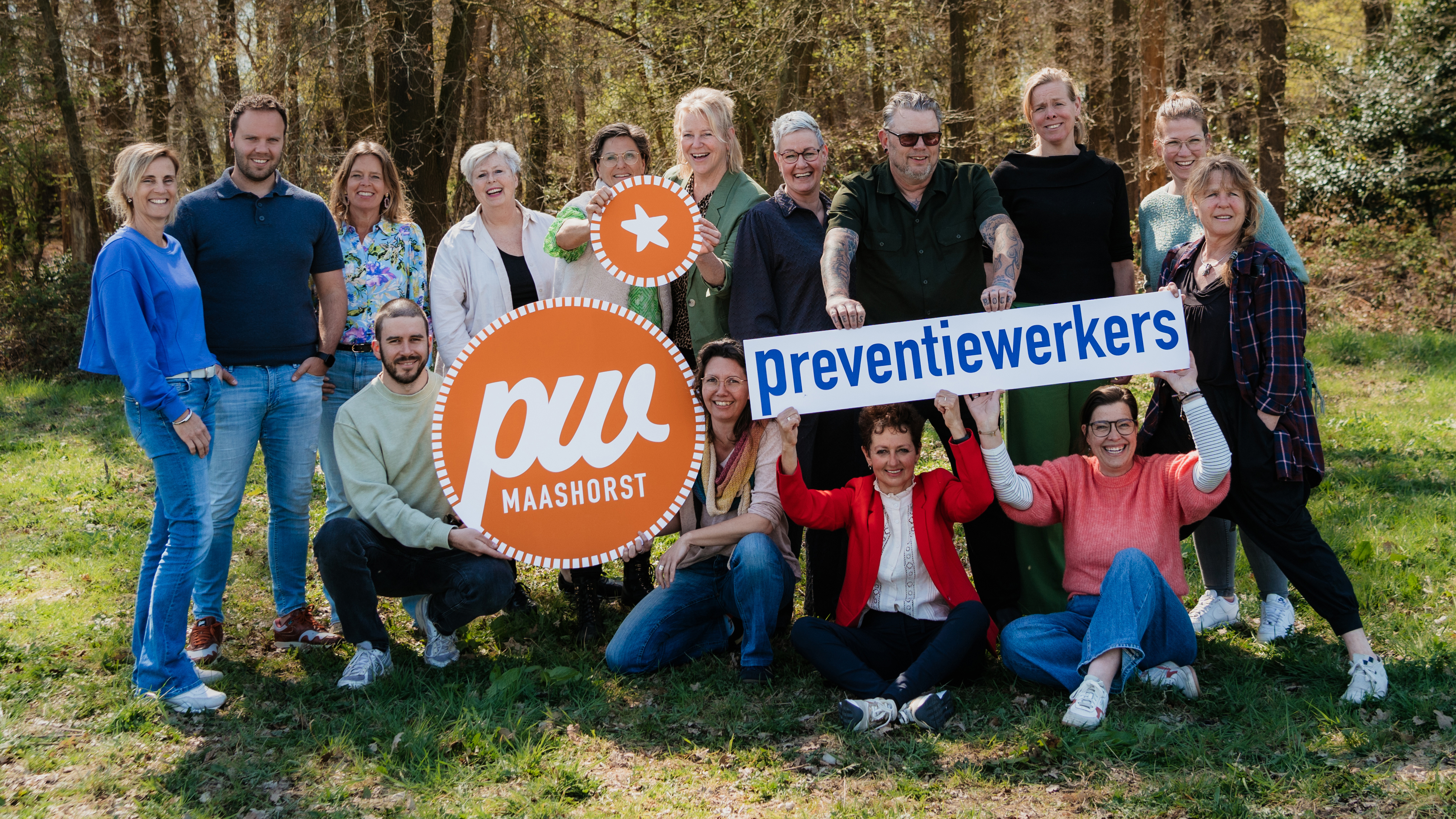 15 preventiewerkers uit gemeente Maashorst. Blije gezichten en ze houden een oranje met blauw logo vast. 
