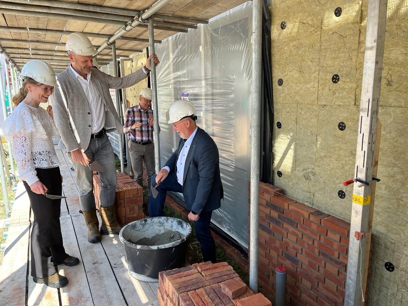 Op de foto v.l.n.r. wethouder Ramona Sour, Bart Kivits (Mooiland) en Bart van Roy (Bouwmij Janssen) die samen de 1e steenlegging bij de volgende fase van het woningbouwproject Kerkstraat Oost in Zeeland doen.