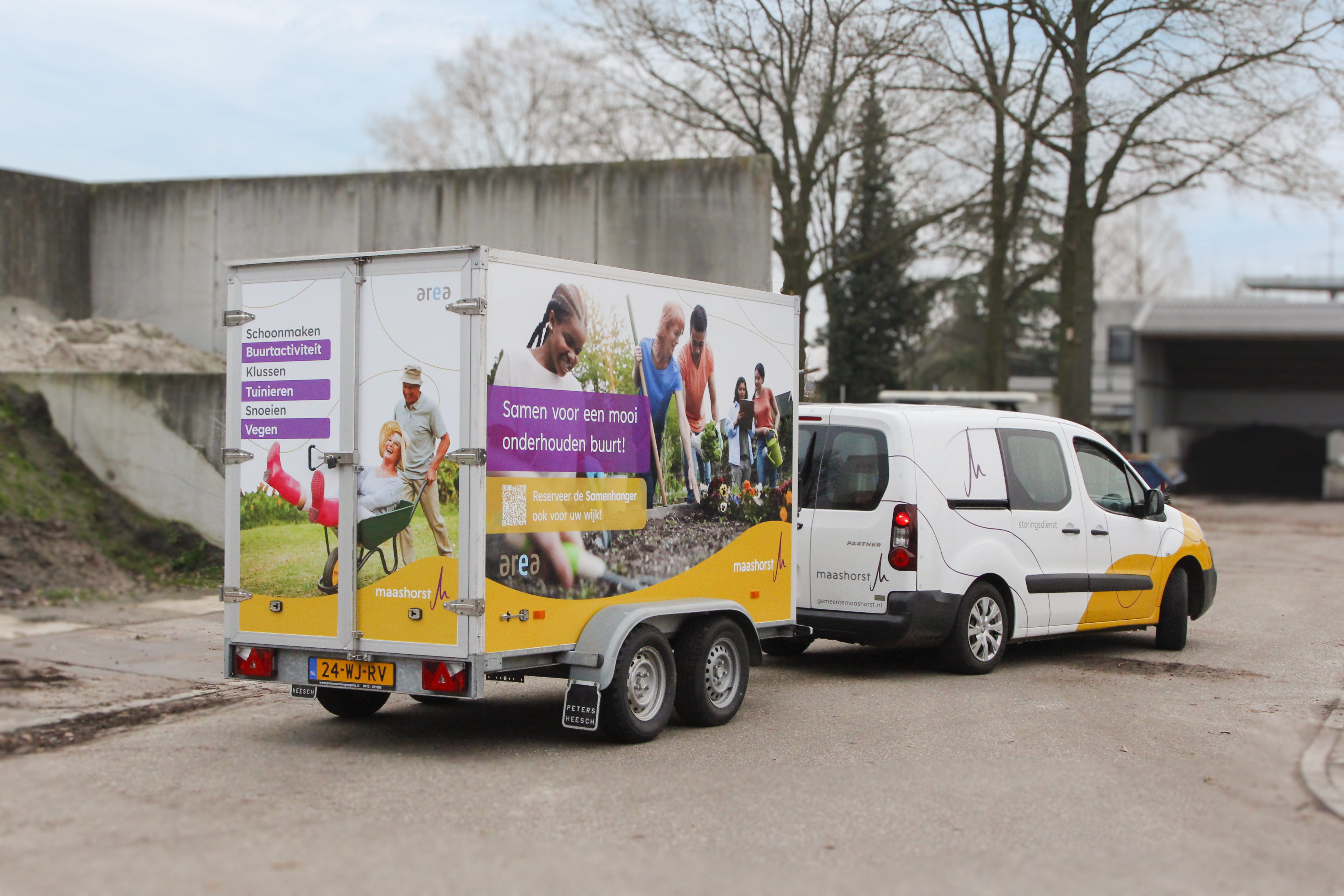 Een aanhanger van de gemeente Maashorst, met een afbeelding waarop buurtbewoners samen tuinieren. Op de aanhanger staat de tekst "Samen voor een mooi onderhouden buurt".