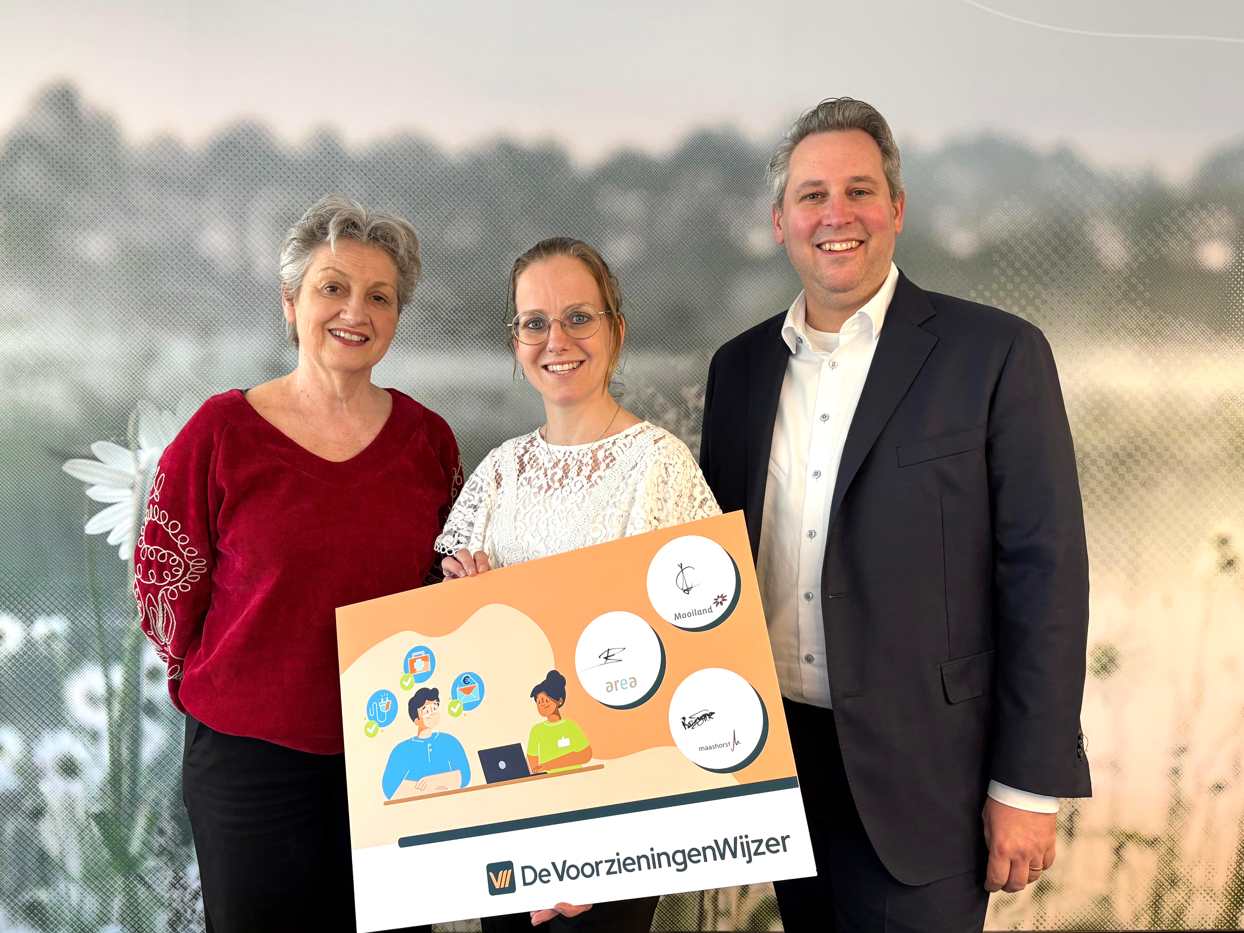 Van links naar rechts Carly Janssen (Mooiland), Wethouder Sour (zorg en welzijn) en Patrick Barské  (Area) tonen de ‘symbolische’ samenwerkingsovereenkomst voor de lancering van De  VoorzieningenWijzer voor Maashorst.