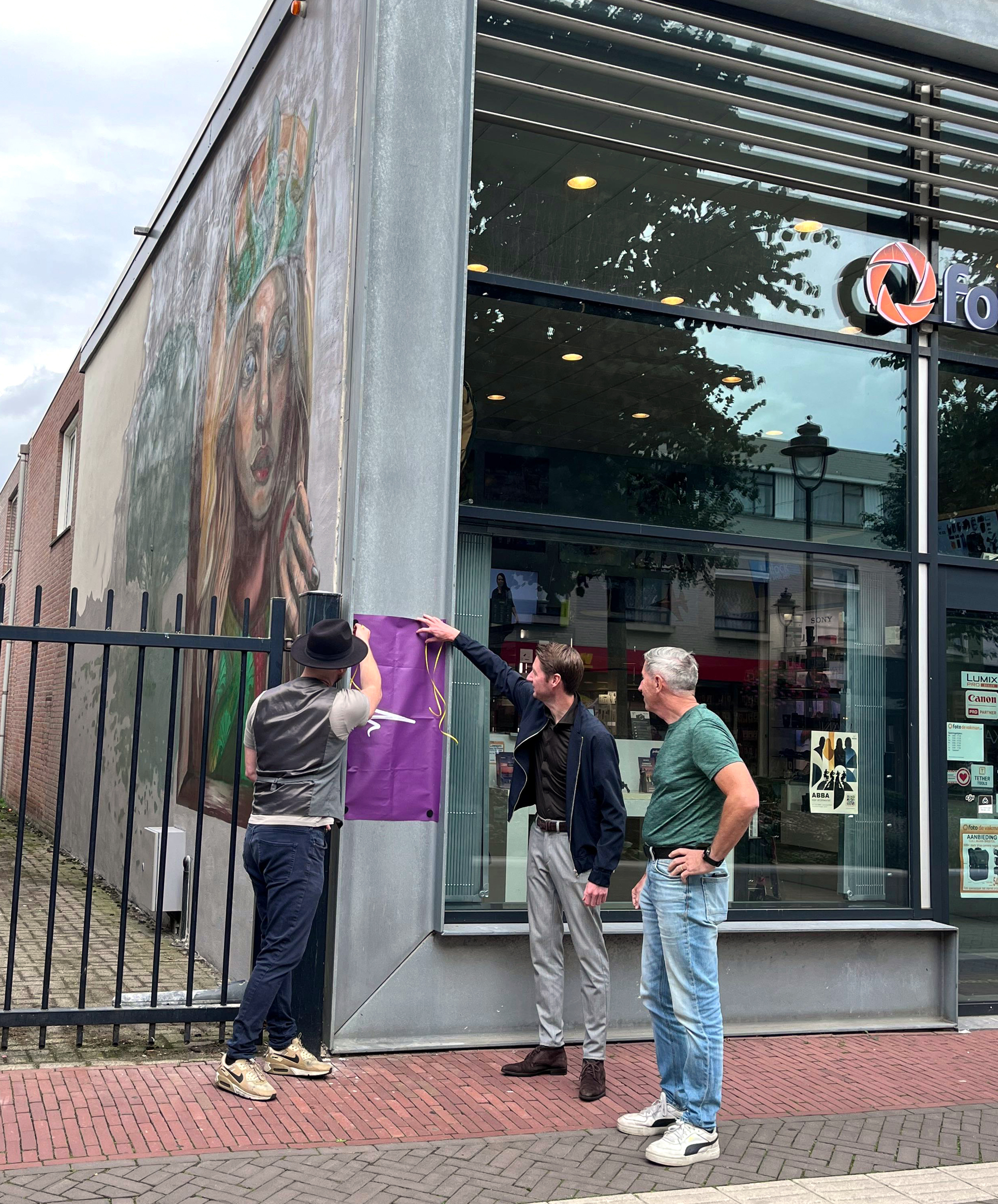 Kunstenaar Pablo Slenders en wethouder Niek van Lanen onthullen het informatiebord bij het kunstwerk aan de Markstraat in het centrum van Uden.